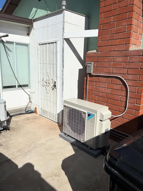 Condenser installed beside a brick wall with new line set and disconnect